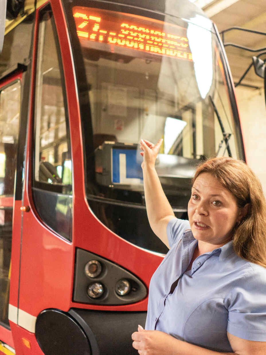 Woman pointing to a tram