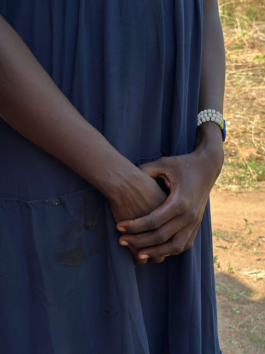 Meyram är ung mamma i Uganda, hon blev ofrivilligt gravid som 14-åring. Närbld på hennes händer.