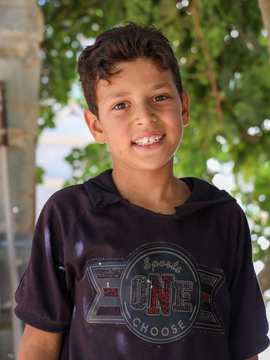 Nawras, a young boy, smiling into the camera