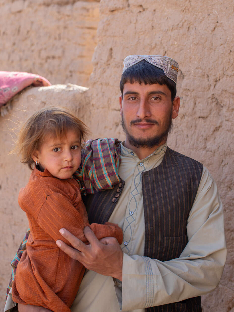 En pappa i Afghanistan med sin dotter i famnen. 