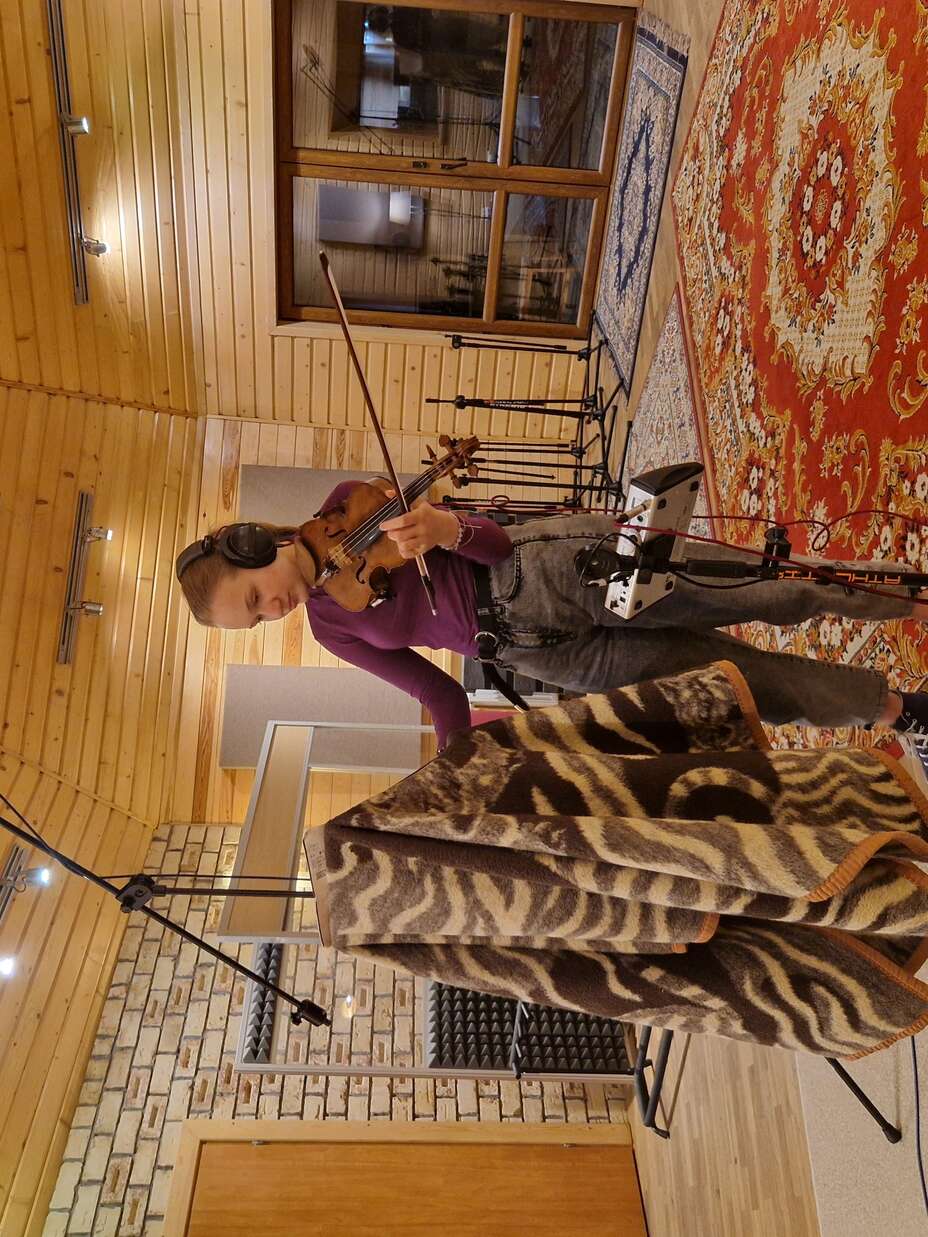 Solomiia plays violin during her recording session at MaQ Records Studio in Poland.