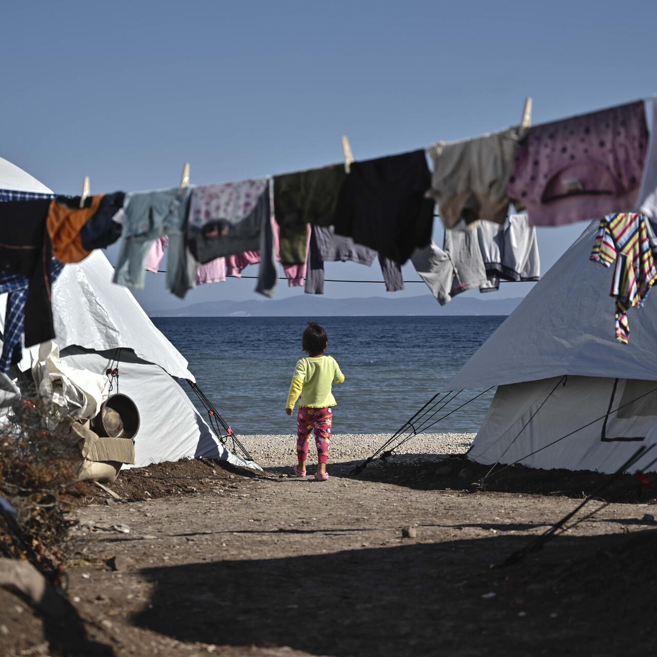 Child stands between tents at the new Lesvos camp