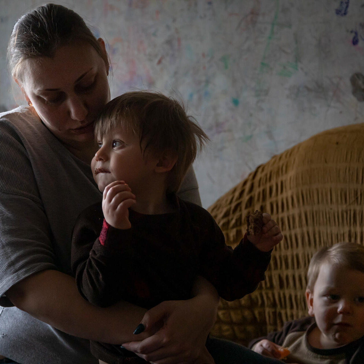 En mamma sitter och håller om sitt barn i Ukraina