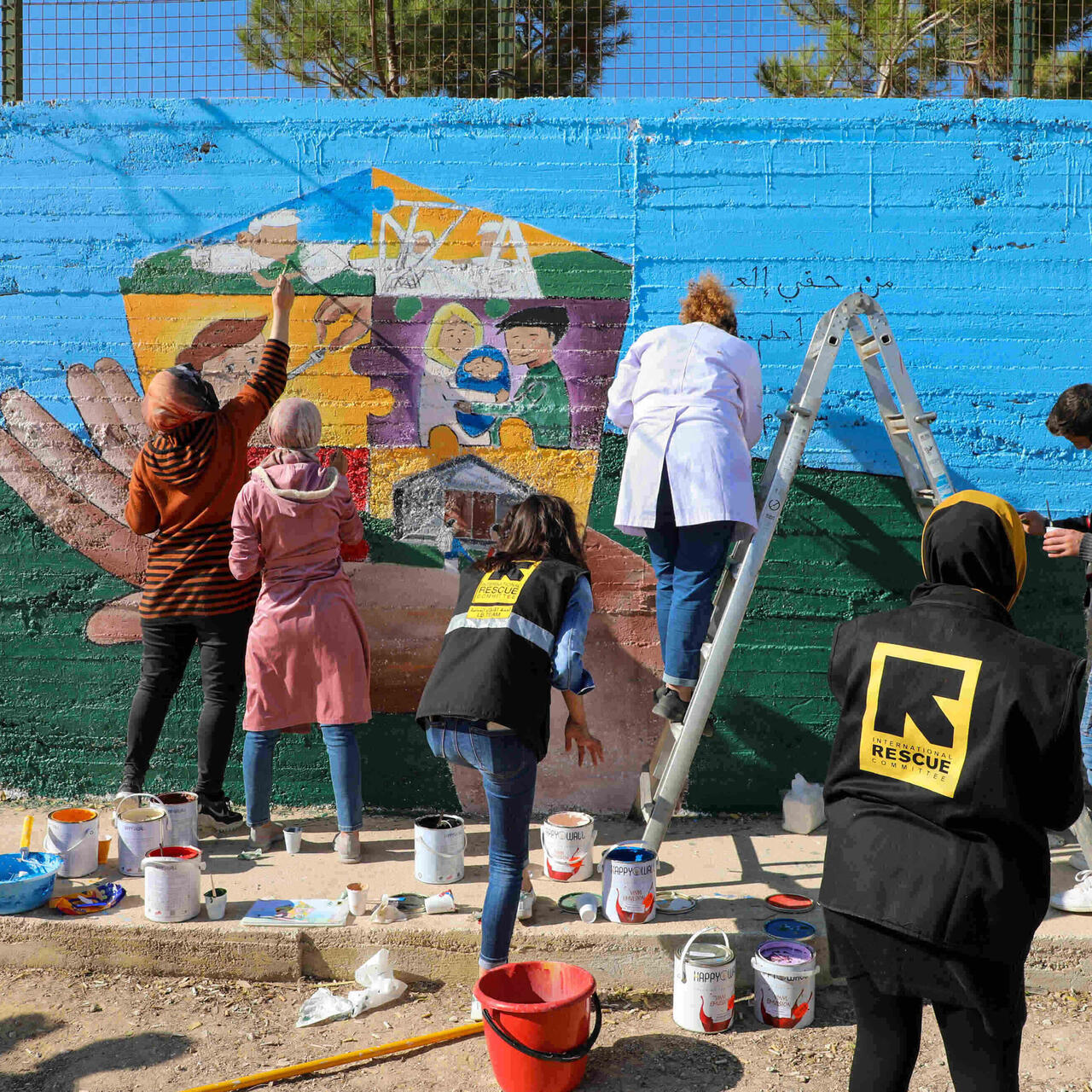 Teenagers taking part in an IRC child protection program in Lebanon paint a mural for World Children's Day 2021 to help raise awareness of children's rights. Photo: IRC