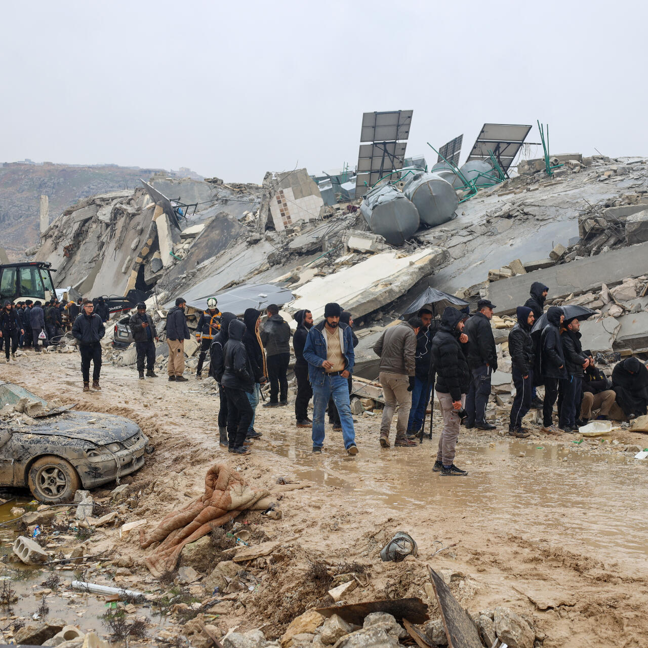 Residents observe a collapsed building.