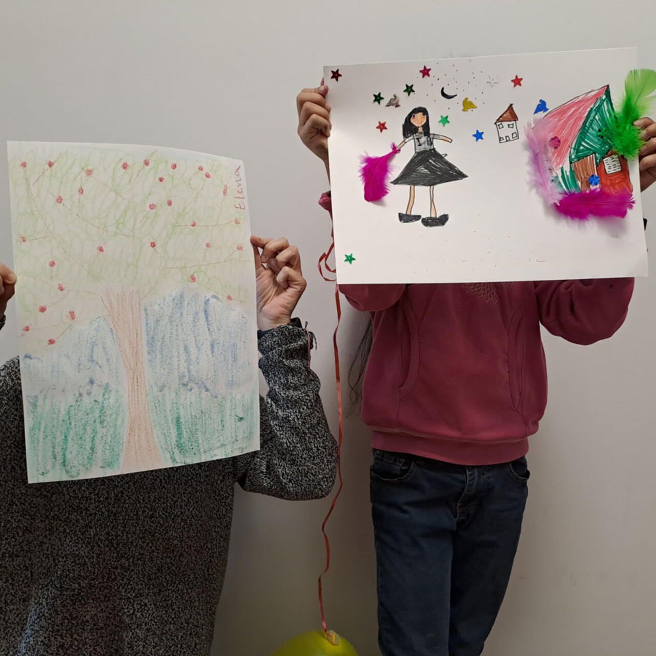 Karima's children holding drawings