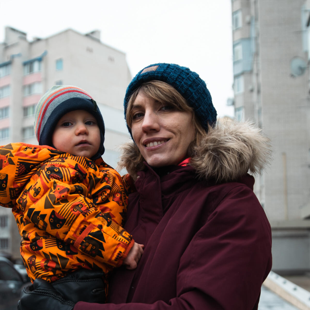 A mother holds her son while posing for a photo.