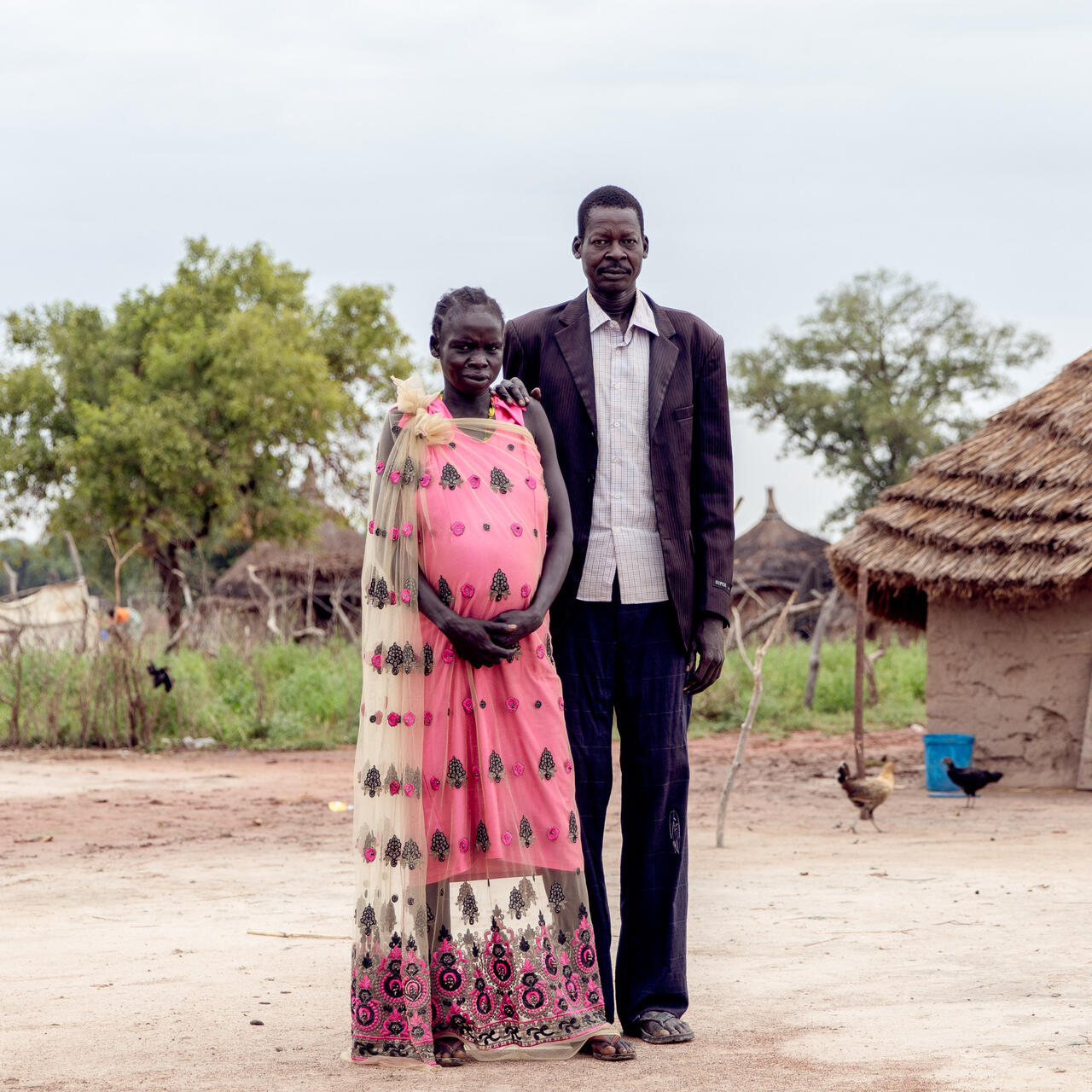 Ein Mann und eine Frau posieren für ein Foto vor ihrem Haus im Südsudan.