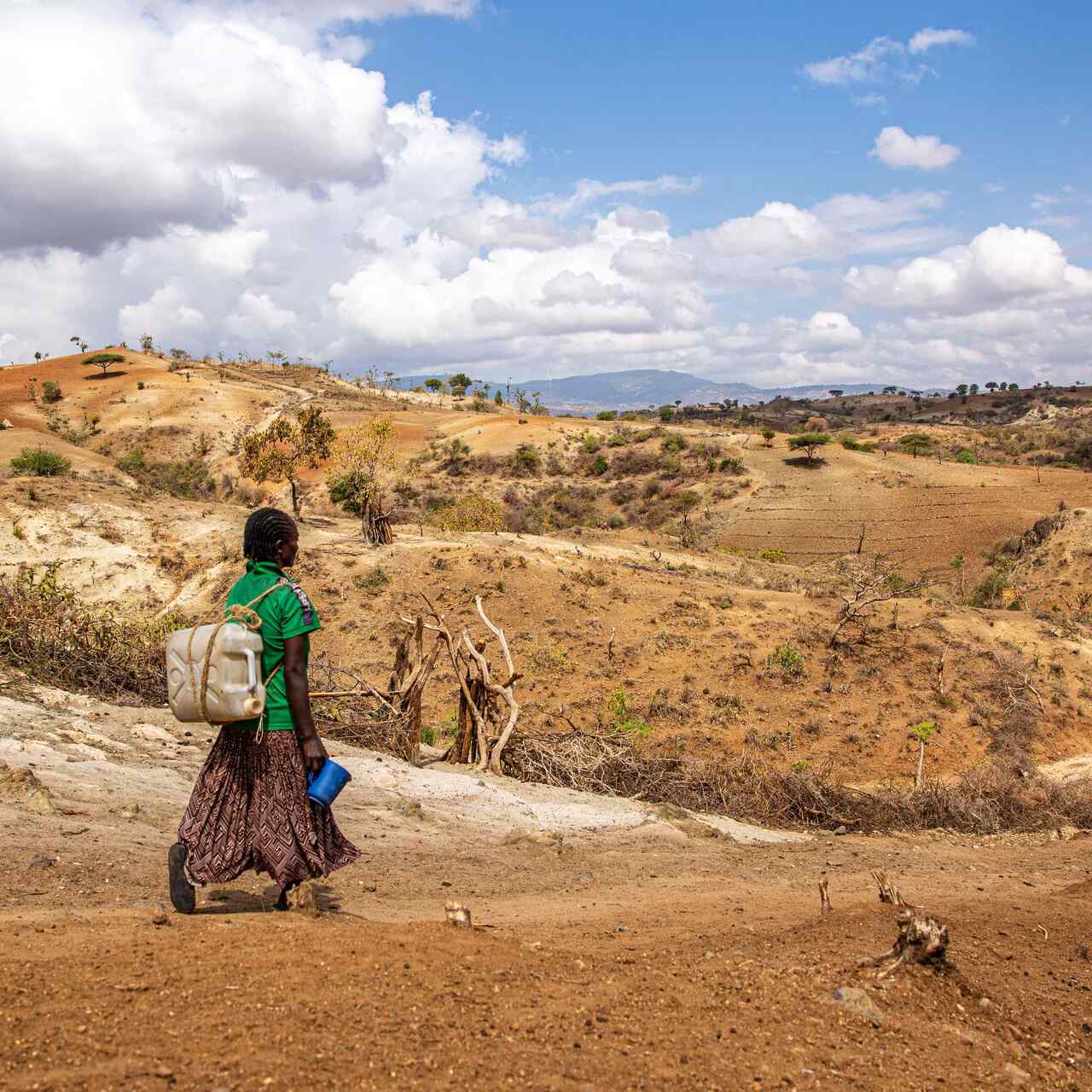 Makito walking 3 kilometers to fetch water for her family. While conflict forced Makito and her family to flee for their lives empty-handed, it’s climate change that’s kept her from being able to rebuild her life without access to the water and resources she needs to start farming again. 