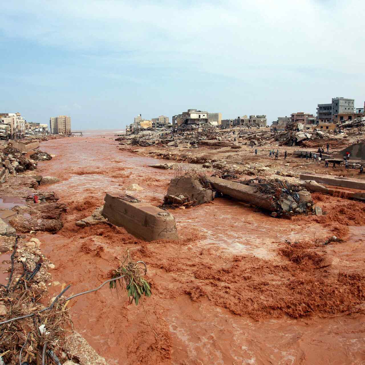 A large portion of the city of Derna, Libya has been swept away by floodwaters. Residents inspect the damage.