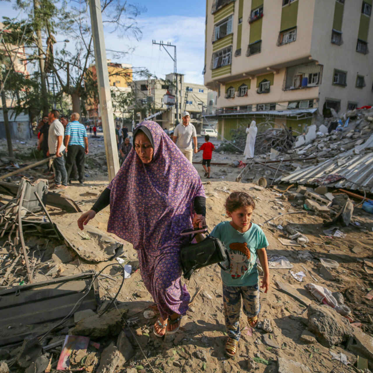 Eine Mutter und ihr Kind gehen durch die Zerstörung, die durch israelische Luftangriffe in Gaza-Stadt verursacht wurde.