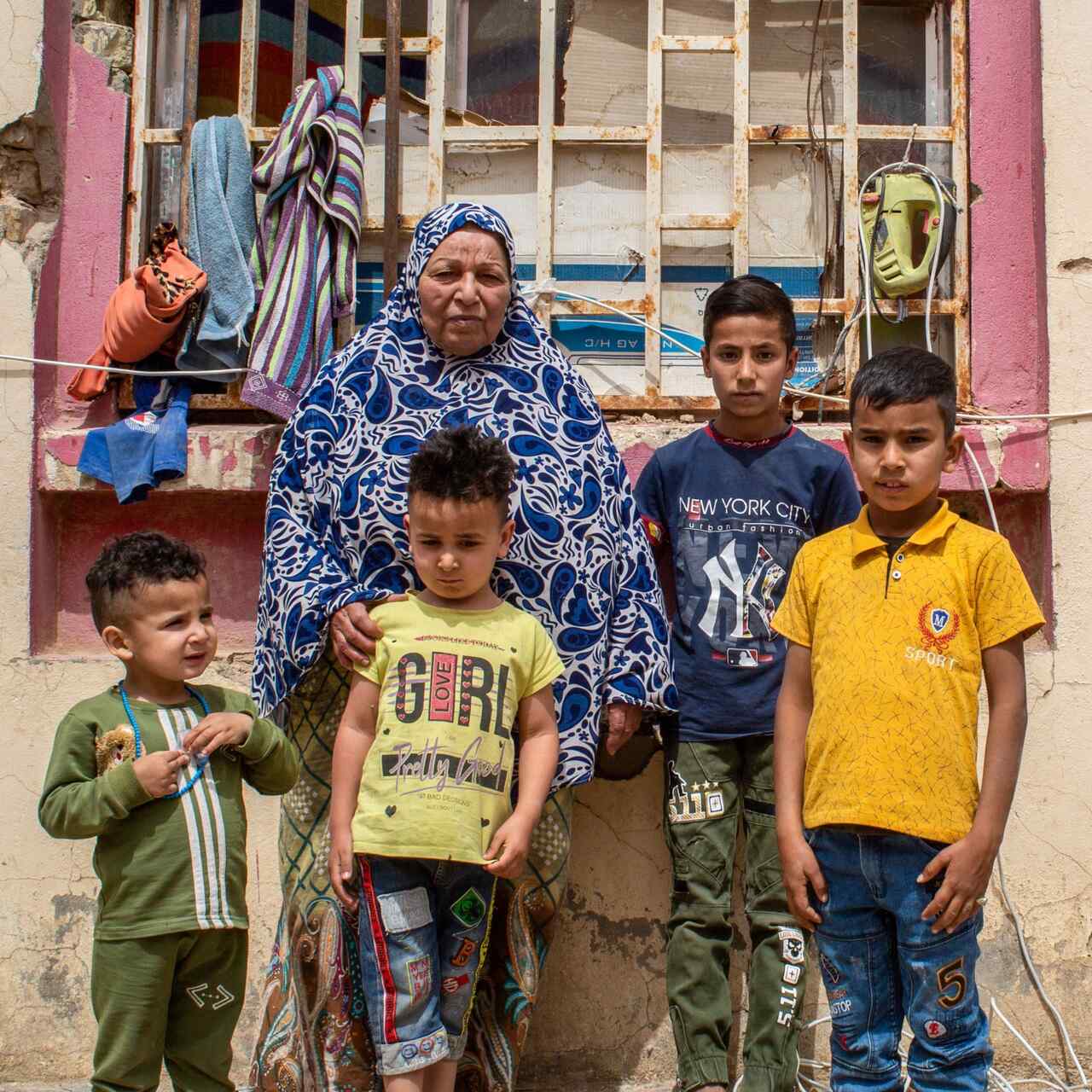 A family stands outside of a building, posing for a photo.