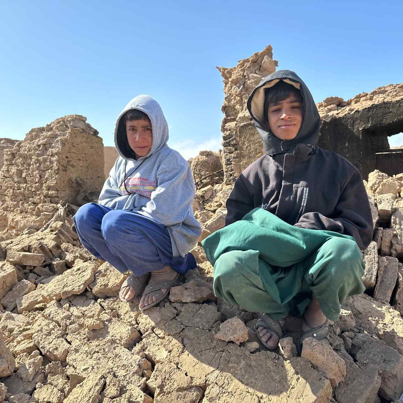 Two boys sit atop a pile of rubble from a building that was destroyed by an earthquake that struck near Herat, Afghanistan.