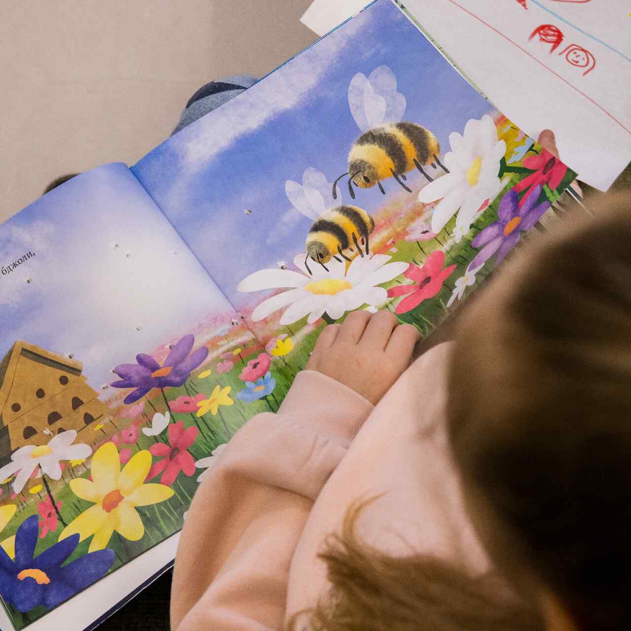 A Ukrainian child reads a book translated to their native language.