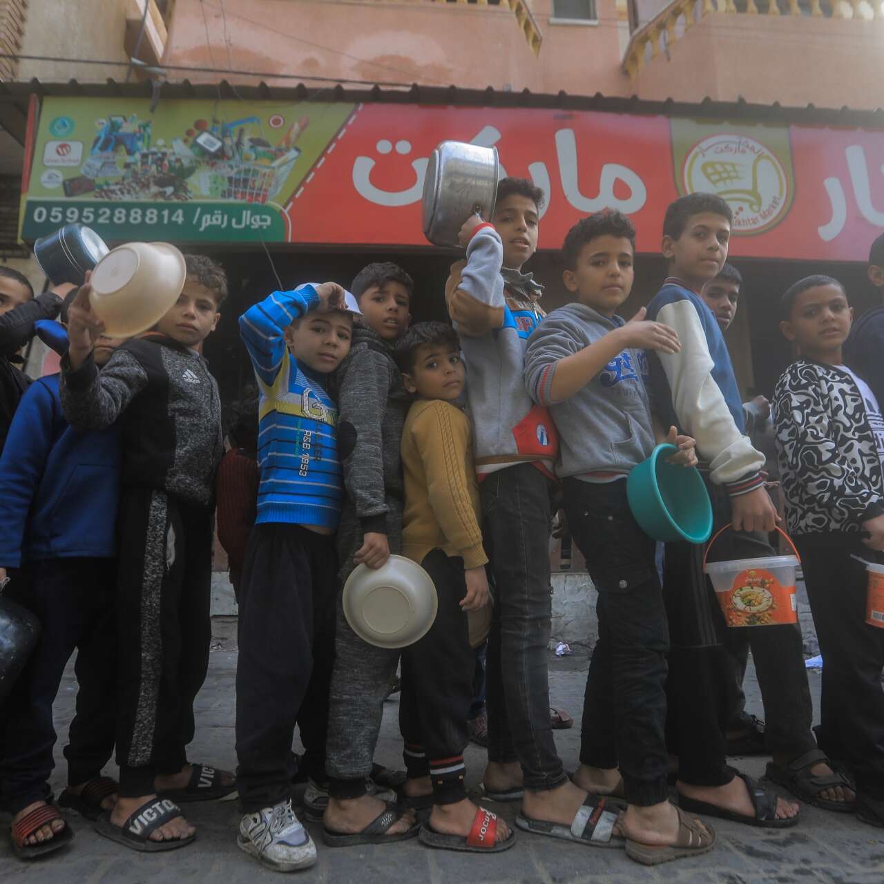 Boys line up in a single-file line waiting for food.