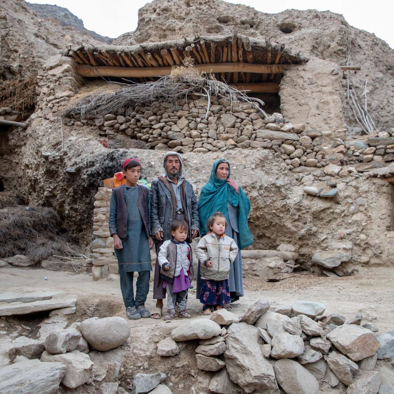 A family poses for a photo together, outside of their rural home in Bamiyan province, Afghanistan.