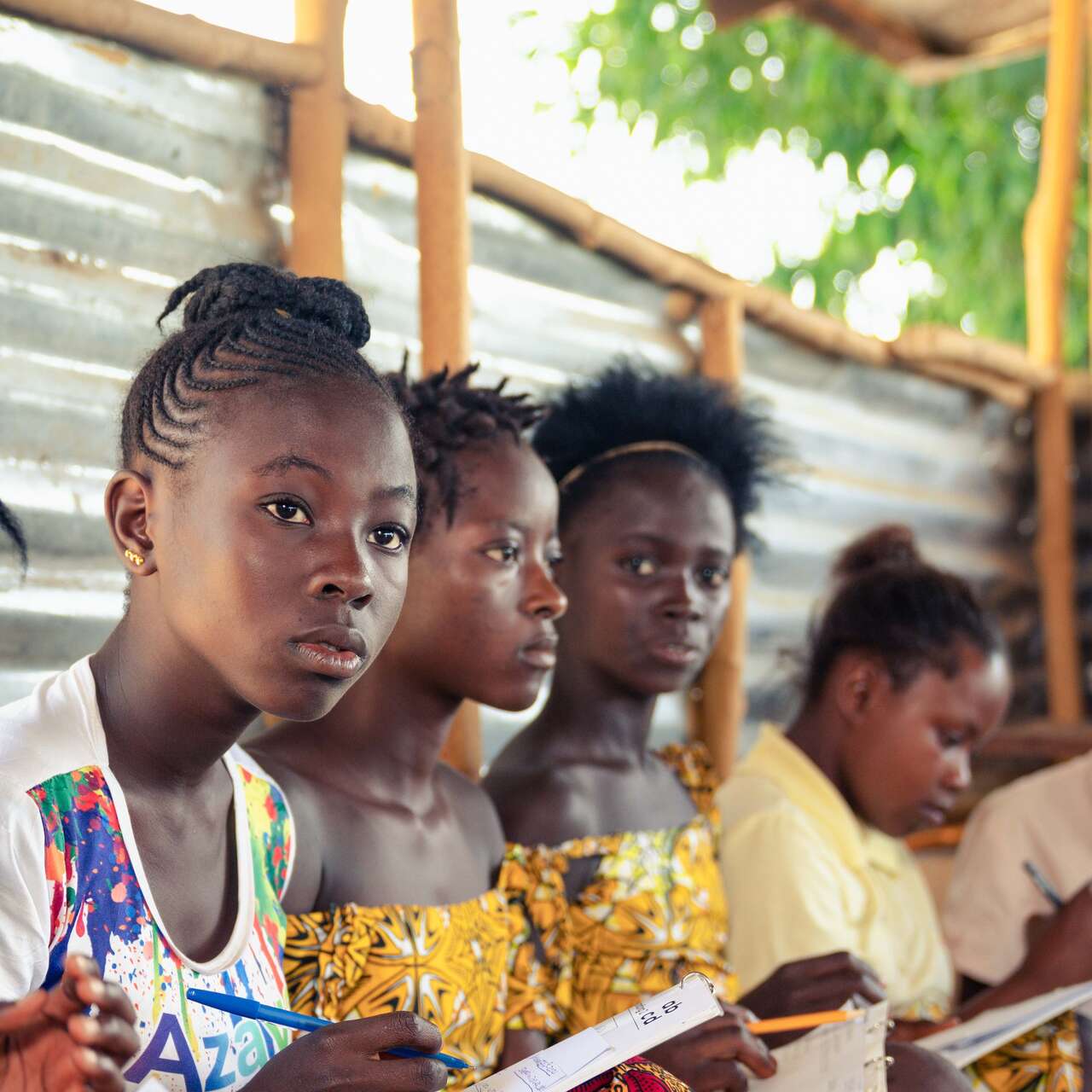 A group of girls take notes during a seminar.