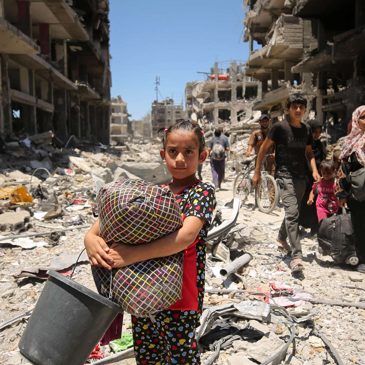 Young girl stands amongst rubble in Gaza.