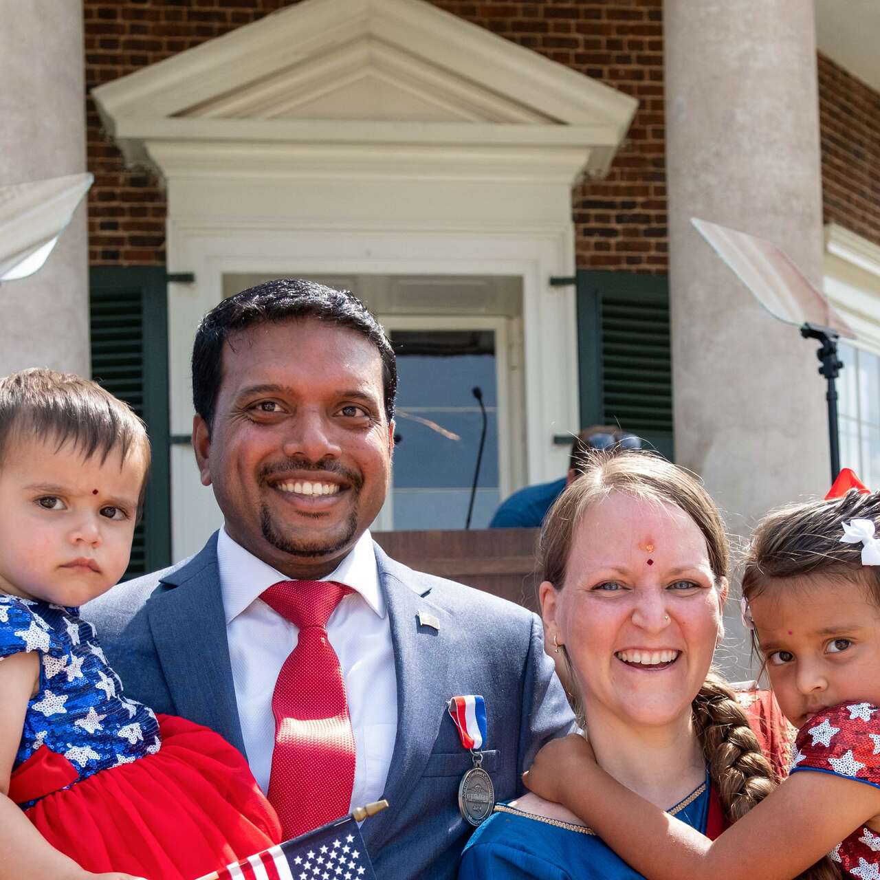 A family poses for a photo at a naturalization ceremony for new American citizens.