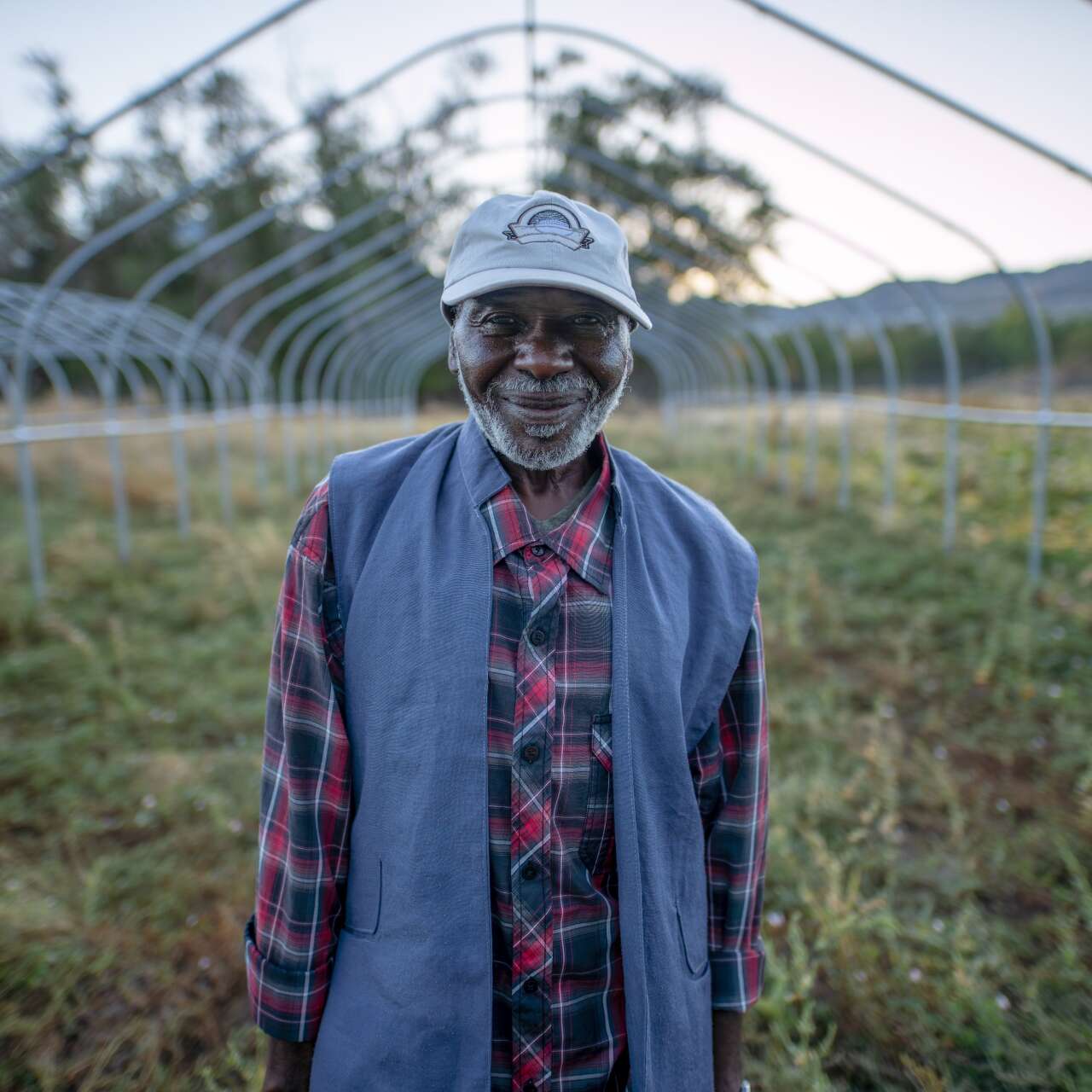 Portrait of Omar, a refugee from Sudan, standing in front of his farm in Salt Lake City, Utah.