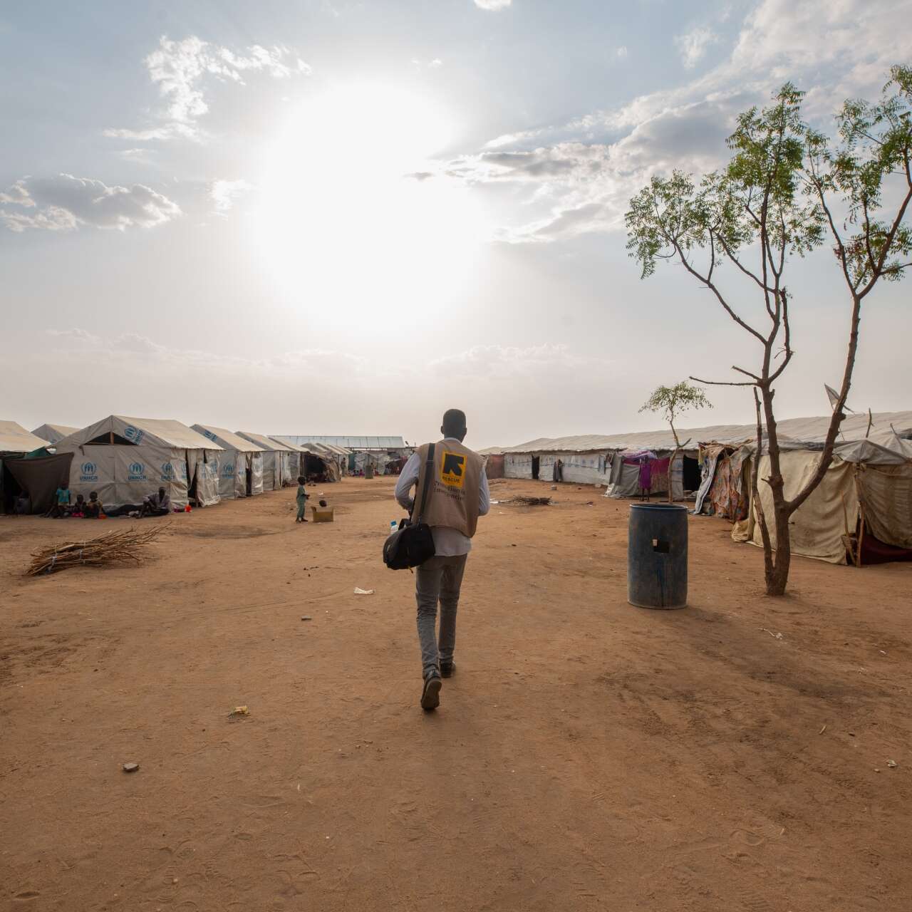 An IRC staff walks towards a camp for displaced people in South Sudan.