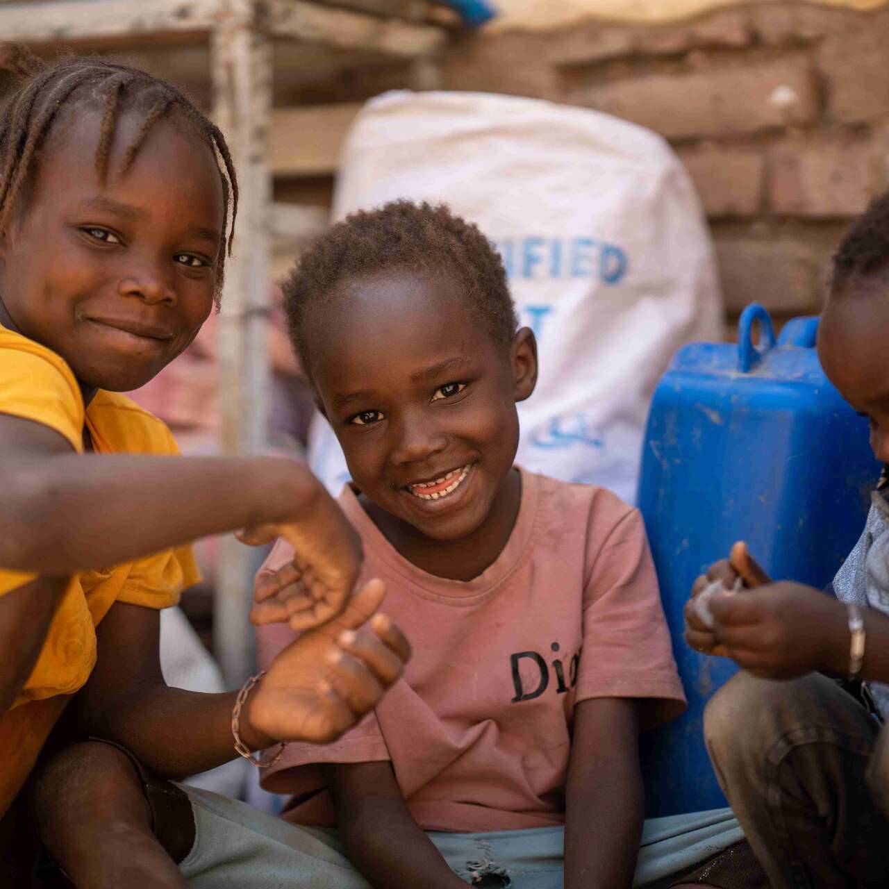 Altuma, a 45-year-old mother of nine, has her children playing together inside their shelter. Displaced from their home in Khartoum by the conflict, her family has had to move several times, and is currently living in an old building without a roof over its head.