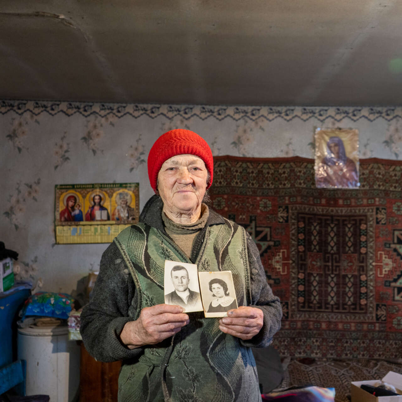 Liubov holds photos of her and her husband in their youth.