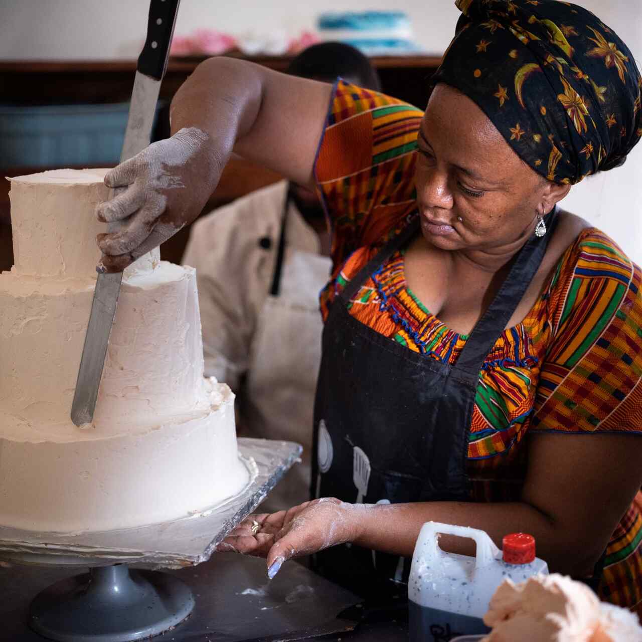 A woman, Suzane, ices a cake