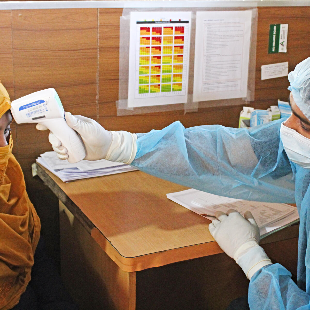 An IRC paramedic checks the temperature of a woman in Cox's Bazar refugee camp in Bangladesh