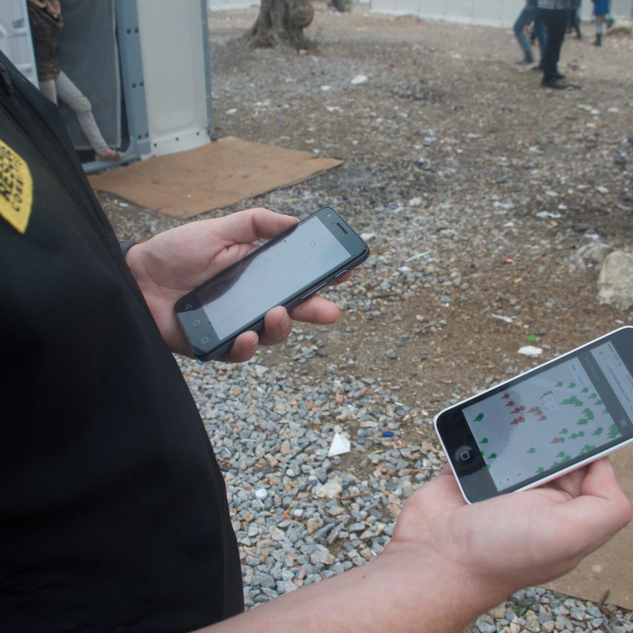 An IRC aid worker in Greece looks at an IRC shelter mapping app on a smartphone. Photo: Kulsoom Rizvi/IRC