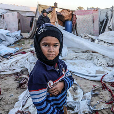 En pojke i Gaza står vid förstörda tält mitt i vintern. RESCUE finns på plats med stöd.