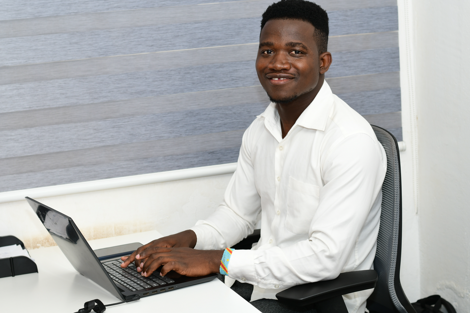 Sebastian works on his computer, and turns to pose for a photo.