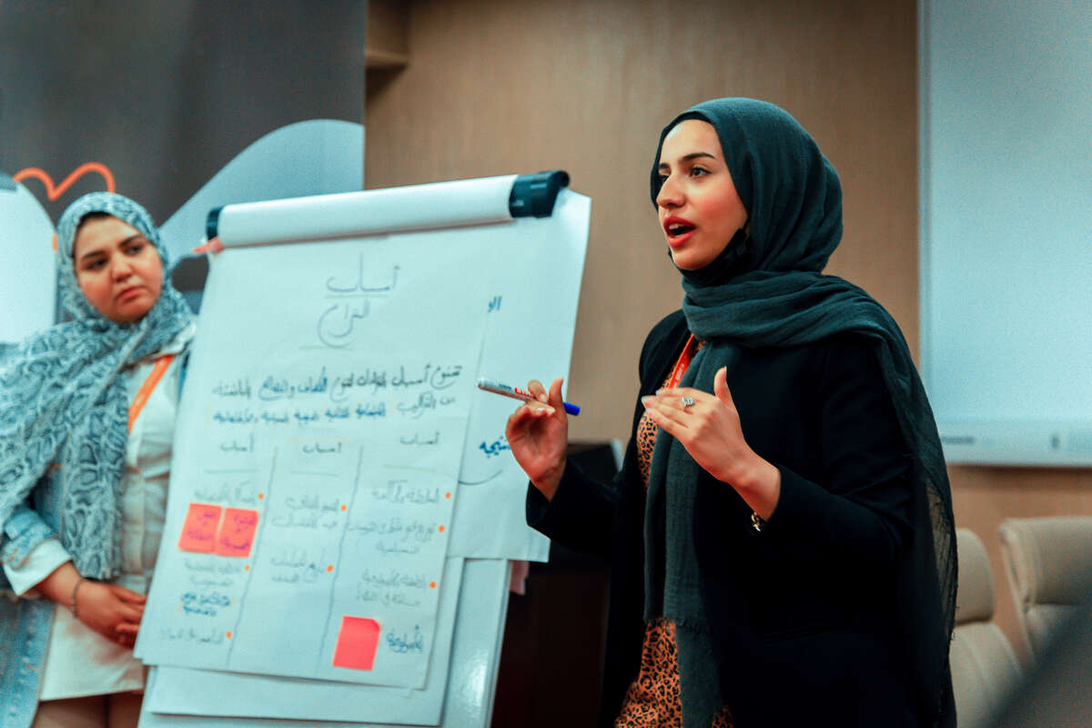 Två kvinnor i Libyen håller i en presentation