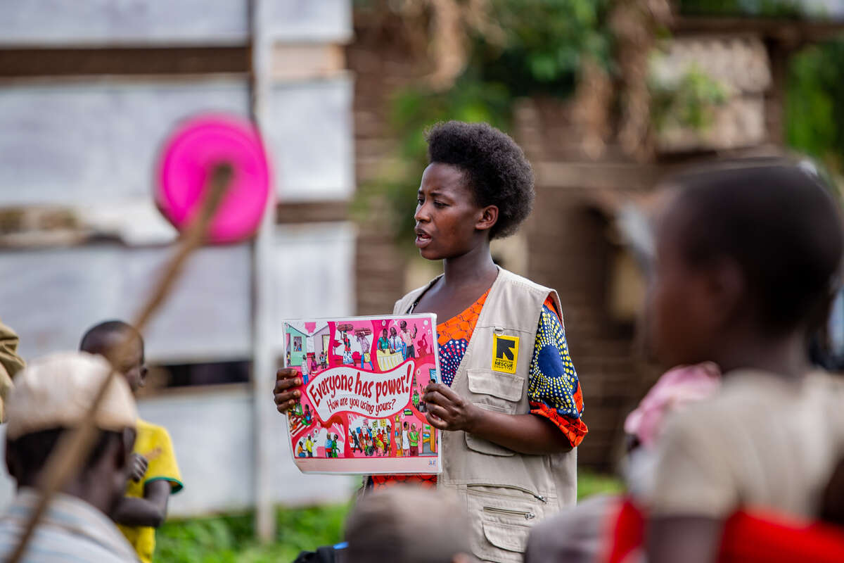 En kvinna i Uganda talar inför en grupp människor