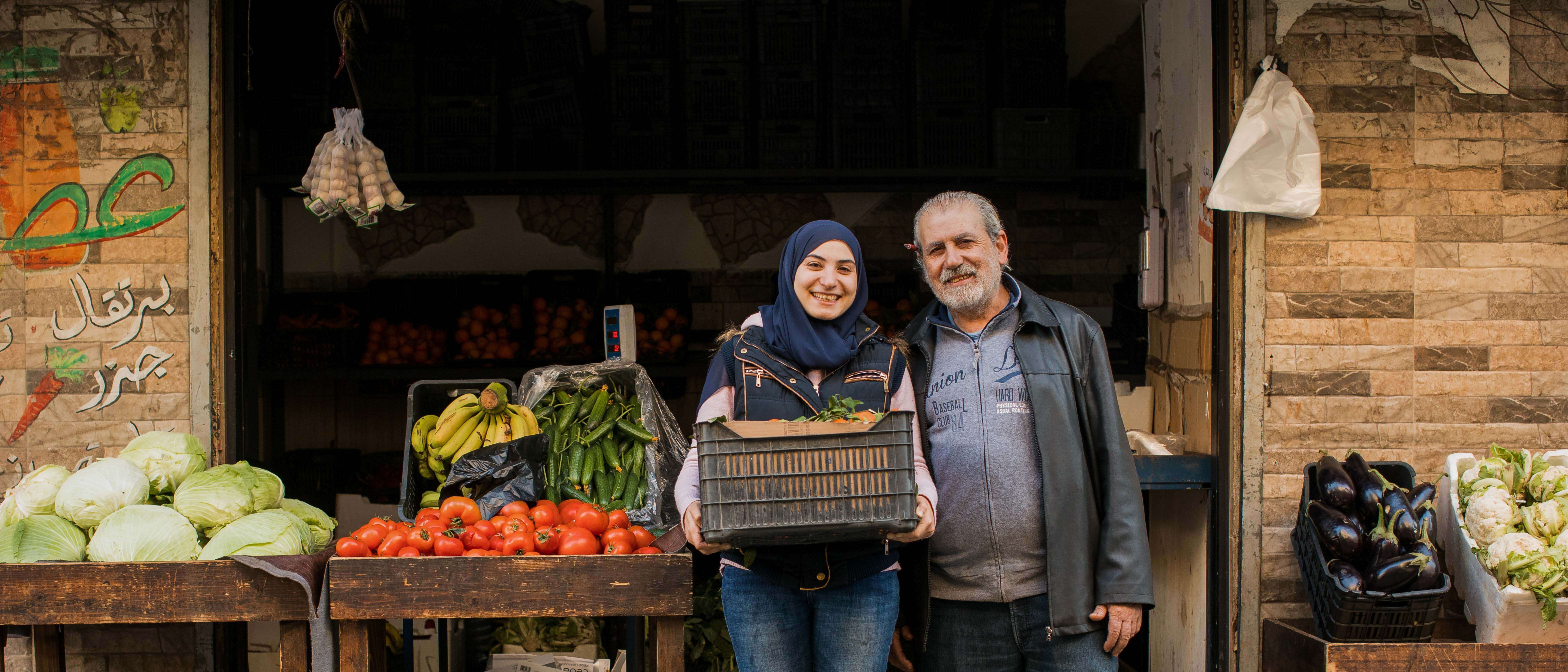 A daughter and father poses for a photo outside of their shop in Lebanon.