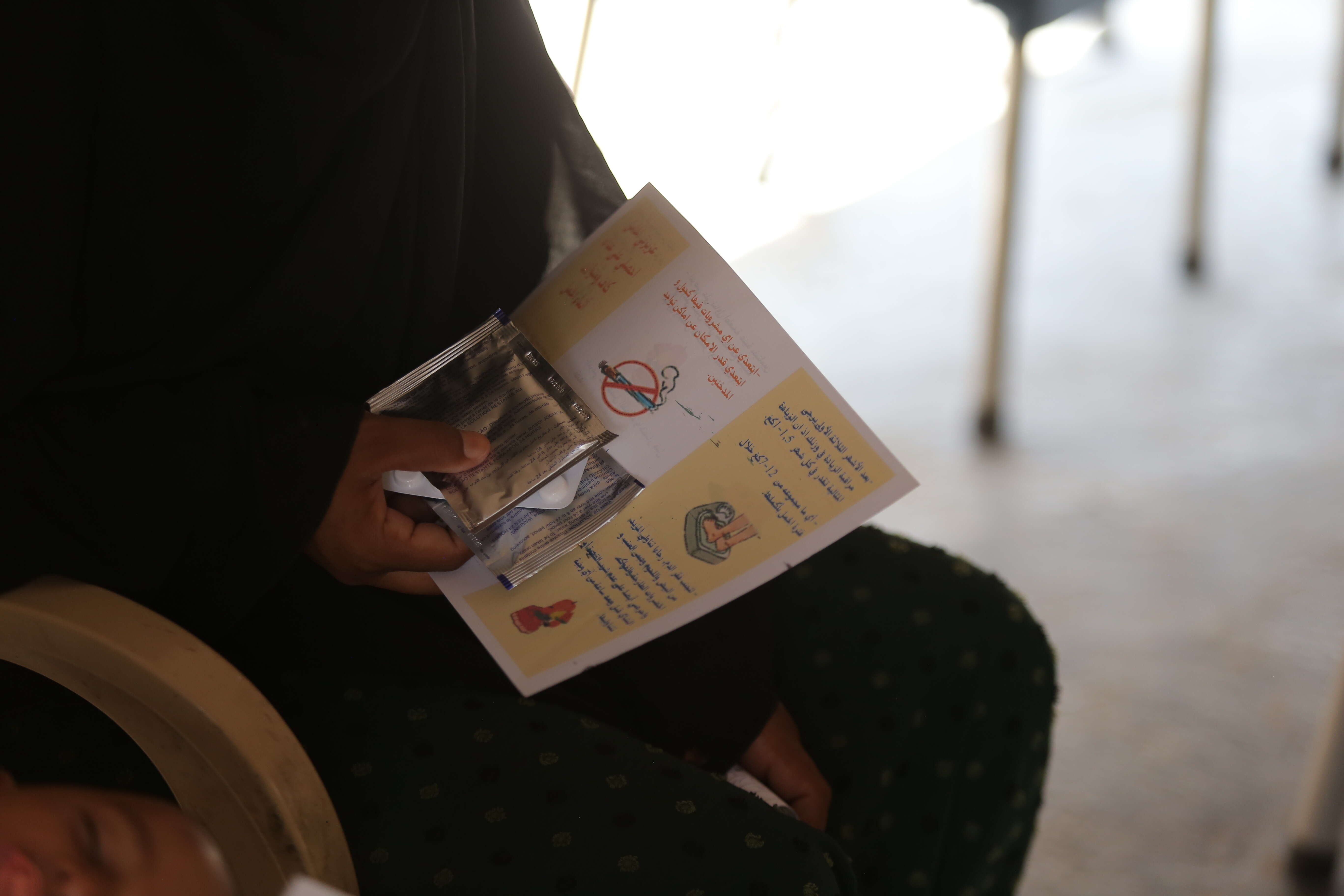 A person holds a health pamphlet in their hands at an IRC health centre in Syria.