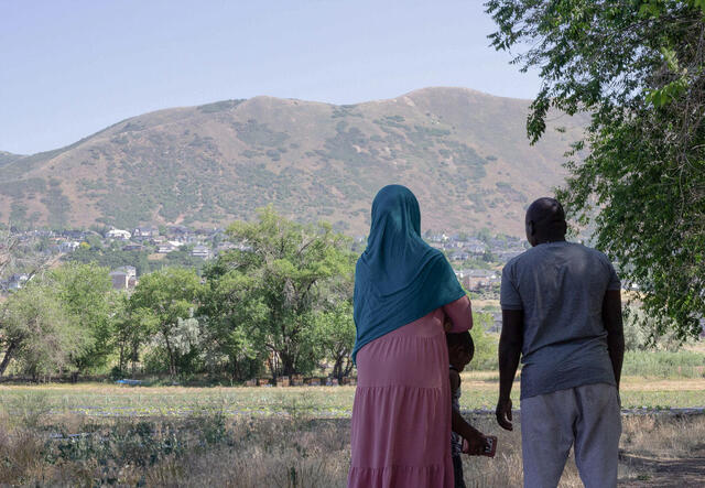 New Roots farmers look out on their field in Salt Lake City with mountains in the background.