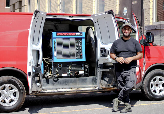 Jose Guevara, small business owner, in front of his cleaning van.