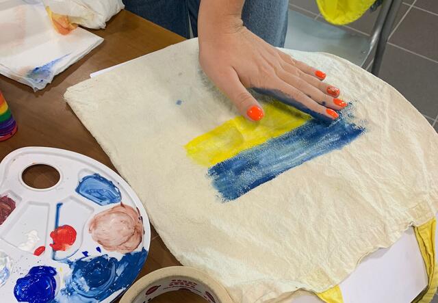 Ukrainian refugee paints the Ukrainian flag during art class in Women and Girls Space in Milan.