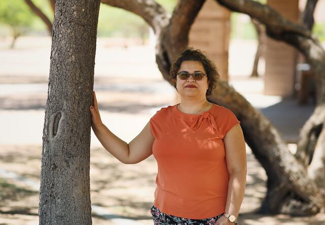 Ritiek, former refugee from Afghanistan, leaning against a tree at a park in Tucson, Arizona.