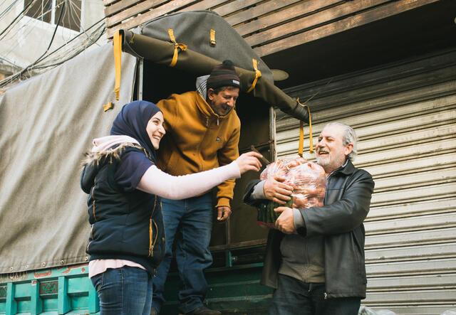 George Balsamarojian delivers vegetables to Ala'a and her father, Hussein Ali Fakih, outside their vegetable shop.