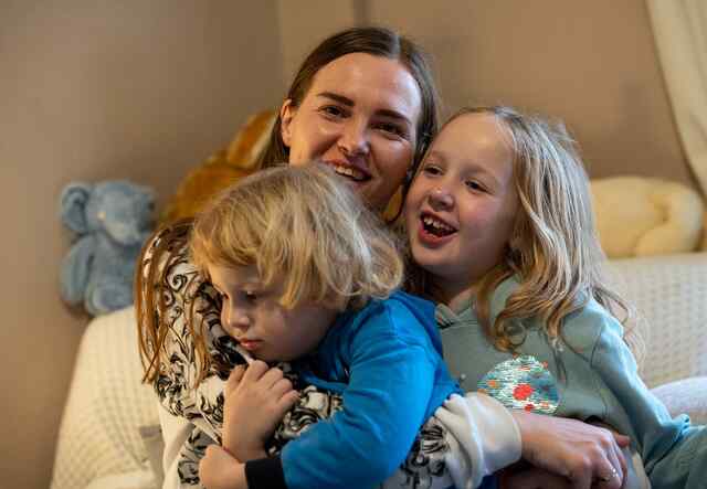 Khrystyna holds her two children in her arms and the family shares a laugh.