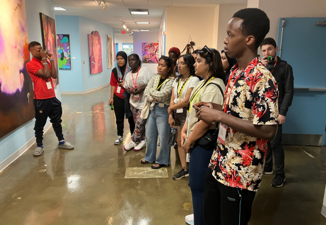 A group of summer camp students standing observing an art piece at the Savannah College of Art & Design.