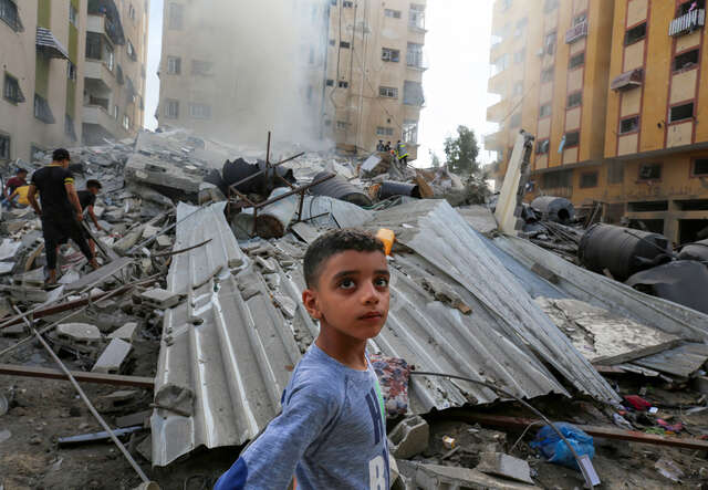 I Gaza står en pojke bland förstörda hus. 