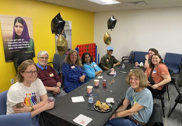 Volunteers sit around a table