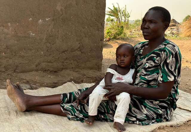 Joyces håller sitt barnbarn i knäet.  Joyces dotter är en av många unga mammor i Uganda.
