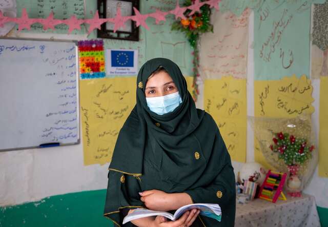 Eine Lehrerin steht vorne in einem Klassenzimmer in Afghanistan.