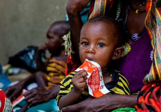Ett barn i Tchad äter nötkräm ur klämförpackning som behandling mot undernäring.