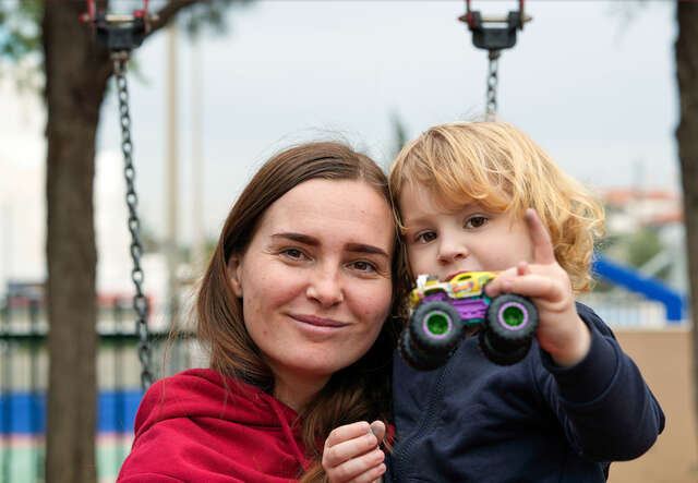 En mamma och hennes son på en lekplats i Grekland, de flydde från Ukraina 2022. 