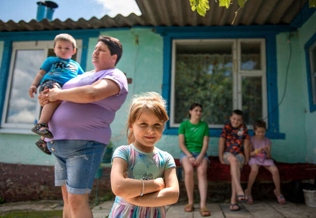 Nataliia, 39, och hennes barn står utanför ett av RESCUE:s hälsocenter i Ukraina. 